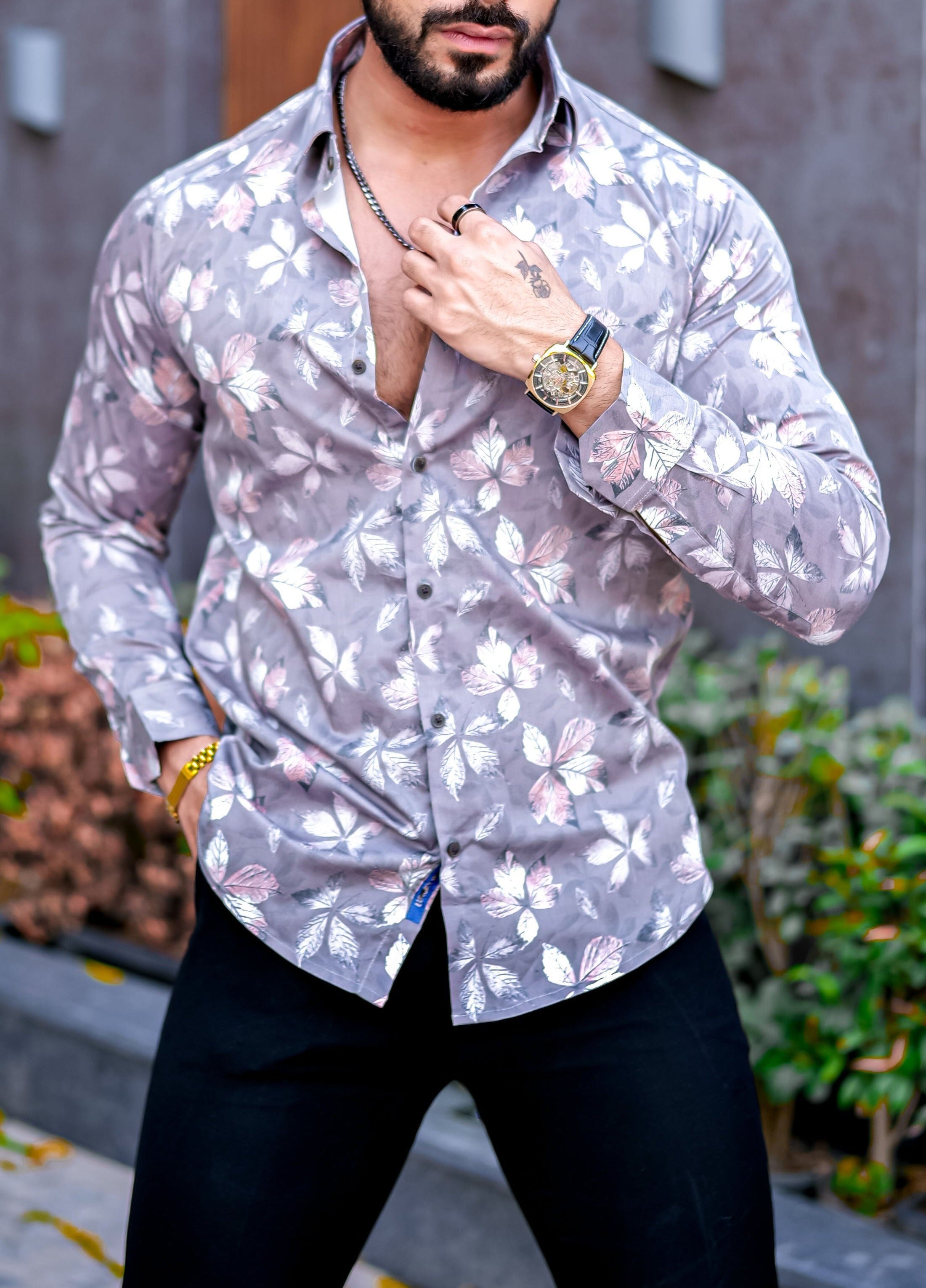 a man in a floral shirt poses for a picture