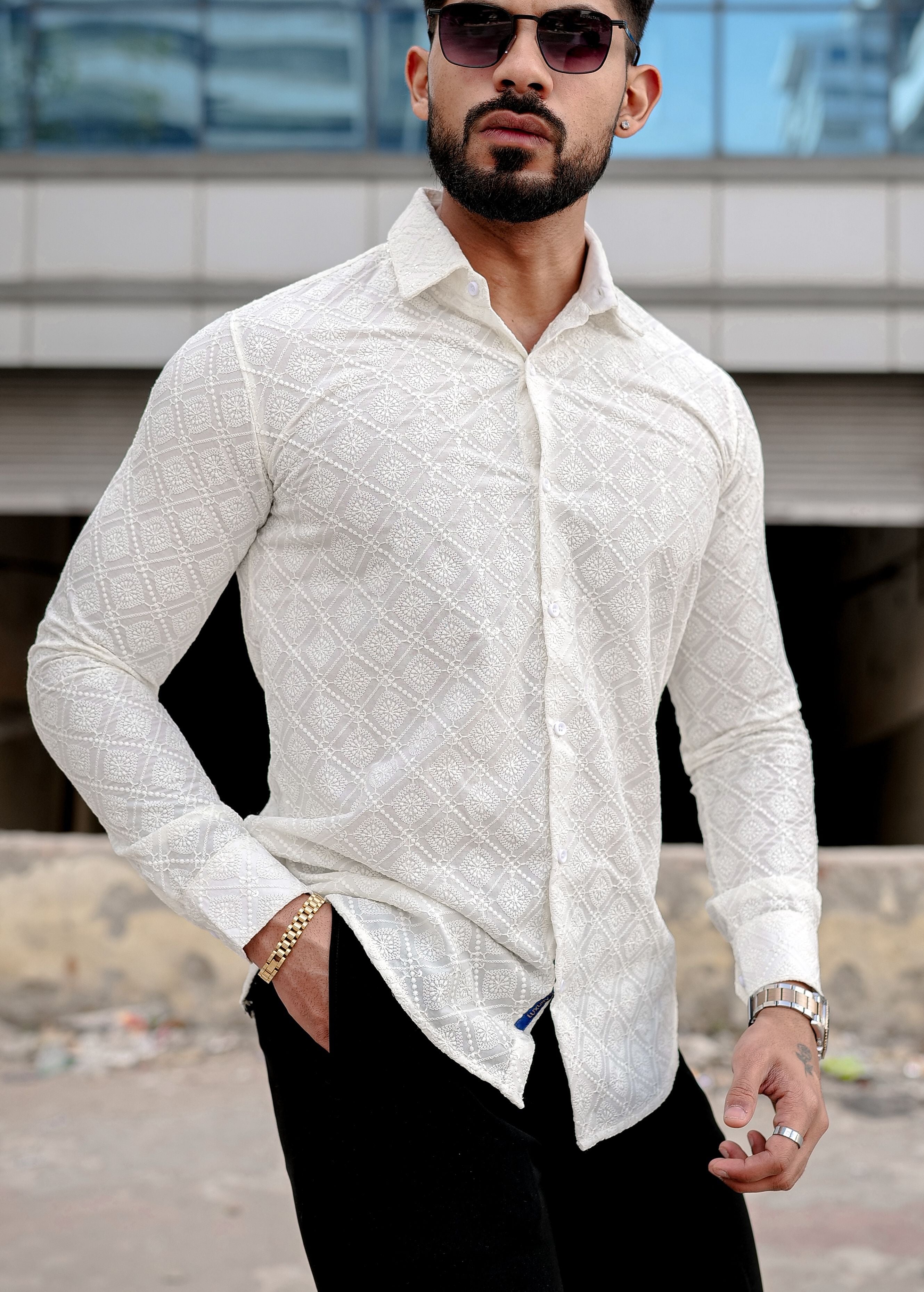 a man wearing a cream shirt and black pants