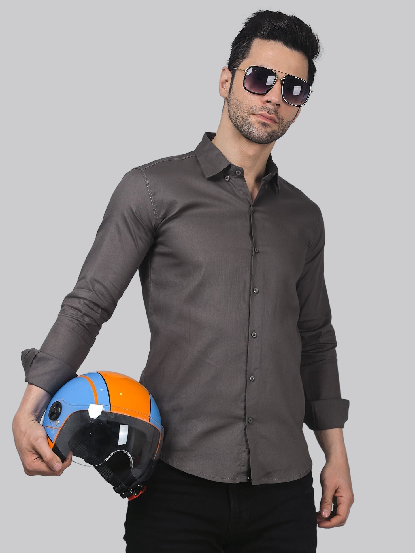 a man holding a helmet and wearing sunglasses