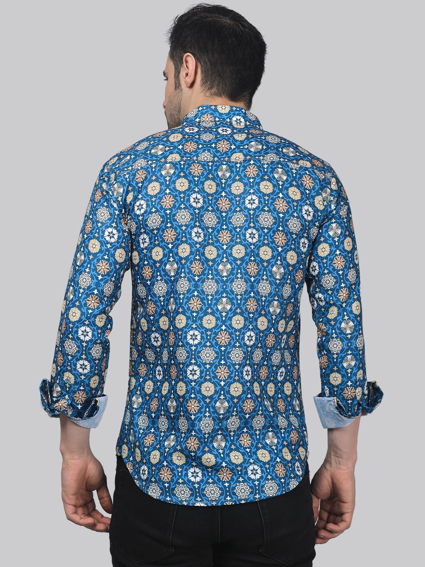 a man wearing a blue shirt with a flower pattern