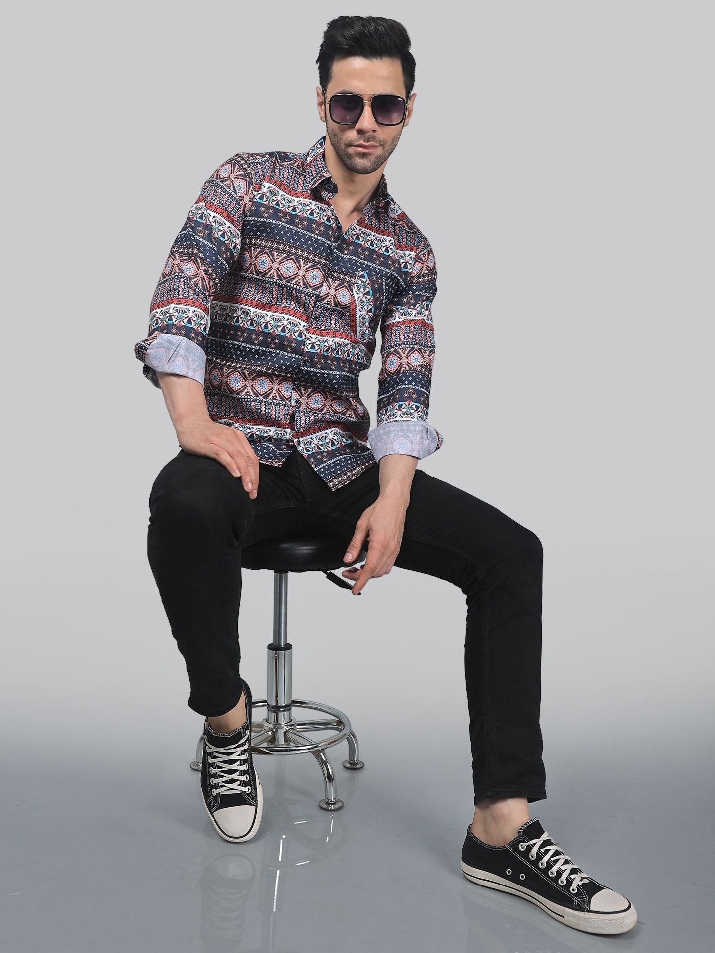 a man sitting on top of a chair wearing sunglasses