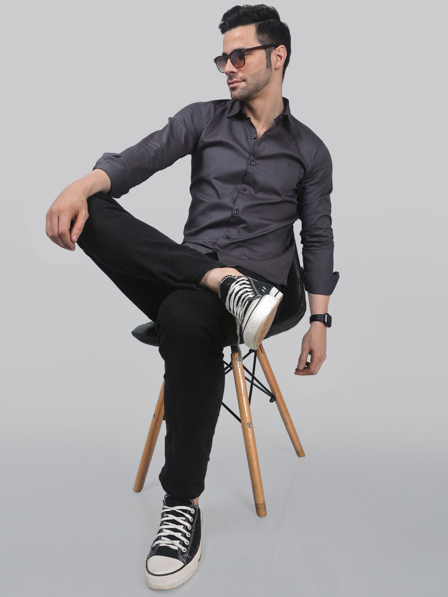 a man sitting on a chair with his legs crossed